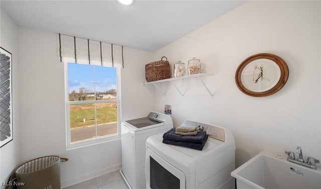 2986 Mcintosh Dr NE, Louisville, OH 44641 - laundry room with washing machine and clothes dryer, light tile patterned flooring, and baseboards