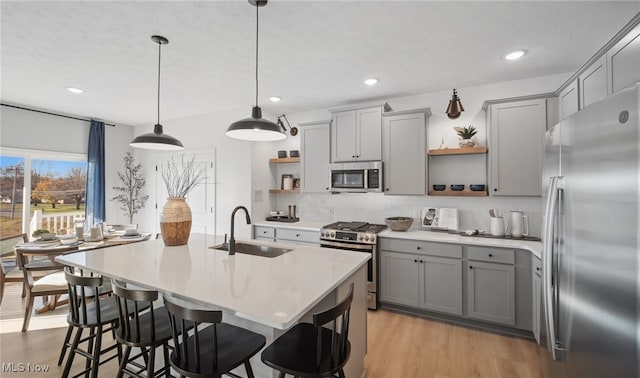 2986 Mcintosh Dr NE, Louisville, OH 44641 - kitchen with open shelves, stainless steel appliances, a sink, gray cabinetry, and decorative backsplash