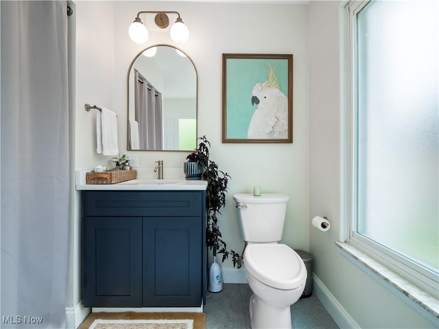 full bathroom with baseboards, toilet, and vanity