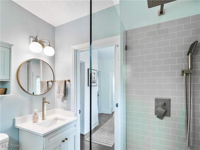 bathroom featuring toilet, vanity, and a textured ceiling