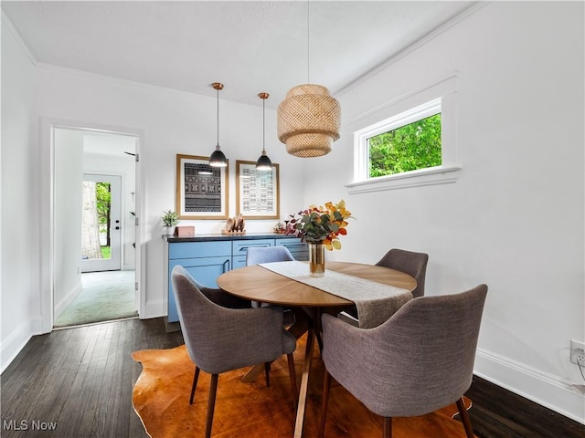 dining area featuring dark wood-style floors, baseboards, and crown molding