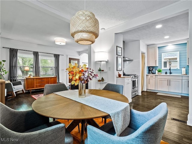 dining space featuring dark wood-style flooring, a textured ceiling, and recessed lighting