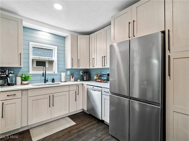 kitchen featuring stainless steel appliances, a sink, light countertops, dark wood-type flooring, and recessed lighting