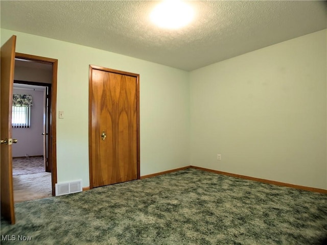 unfurnished bedroom with carpet, a textured ceiling, a closet, and baseboards