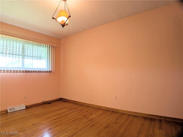 unfurnished room with wood finished floors and baseboards