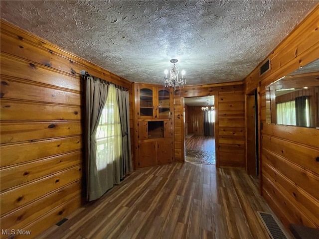 1585 County Road 9, Marietta, OH 45750 - unfurnished living room with a chandelier, wooden walls, dark wood-type flooring, and a textured ceiling