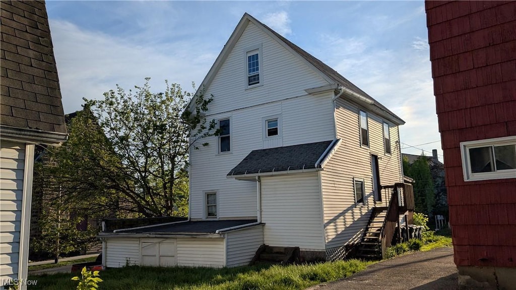back of property with roof with shingles