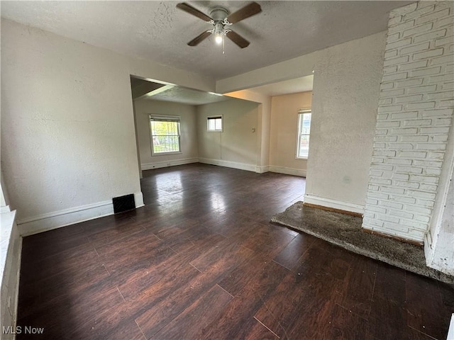 12423 Phillips Ave, Cleveland, OH 44108 - unfurnished living room featuring ceiling fan, baseboards, dark wood finished floors, a textured ceiling, and a textured wall