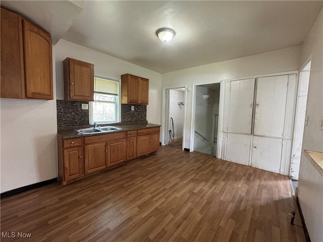 12423 Phillips Ave, Cleveland, OH 44108 - kitchen featuring dark wood finished floors, decorative backsplash, brown cabinetry, and a sink