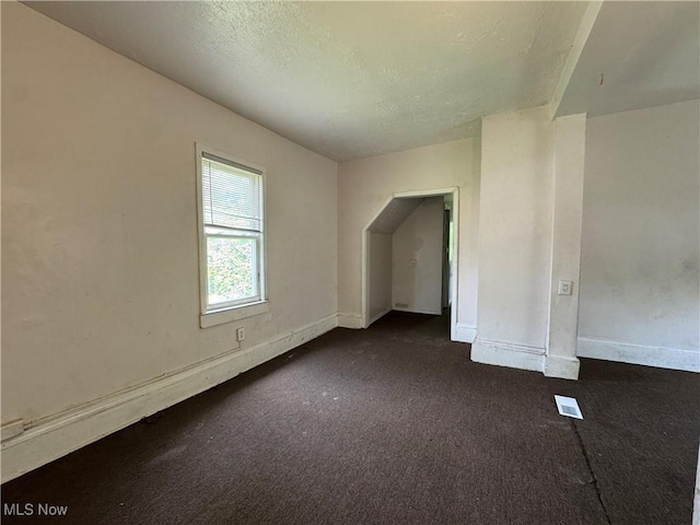 12423 Phillips Ave, Cleveland, OH 44108 - bonus room with dark colored carpet, baseboards, and a textured ceiling