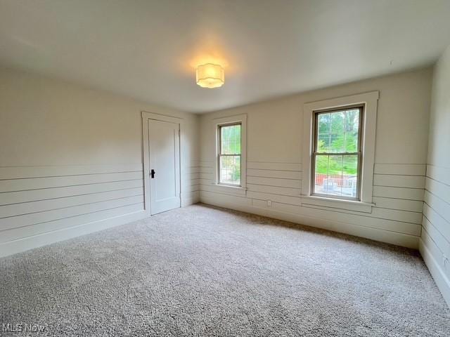 713 N Broadway St, New Philadelphia, OH 44663 - empty room featuring wood walls, carpet flooring, and wainscoting