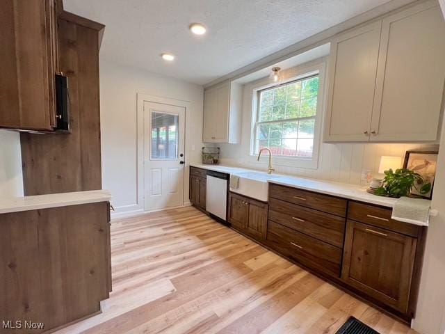 713 N Broadway St, New Philadelphia, OH 44663 - kitchen featuring stainless steel dishwasher, a sink, light wood-type flooring, light countertops, and recessed lighting