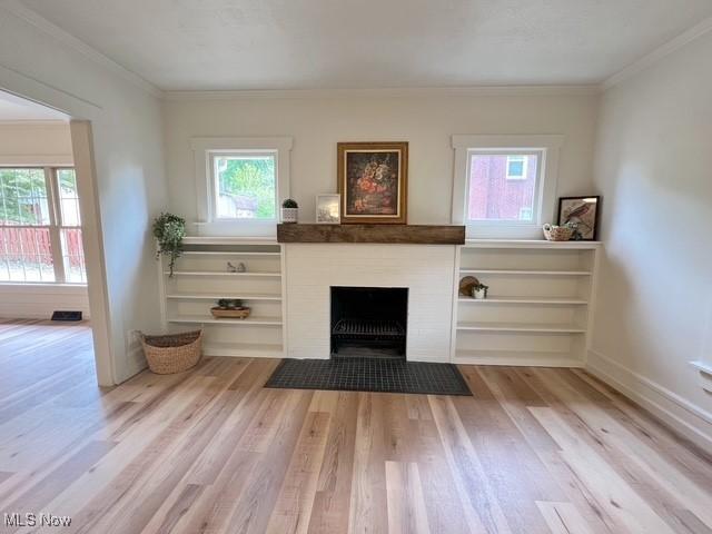 713 N Broadway St, New Philadelphia, OH 44663 - living room featuring plenty of natural light, light wood-style flooring, ornamental molding, and a fireplace with flush hearth