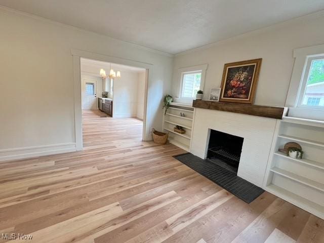 713 N Broadway St, New Philadelphia, OH 44663 - living room with ornamental molding, a chandelier, light wood-style flooring, plenty of natural light, and a fireplace with flush hearth
