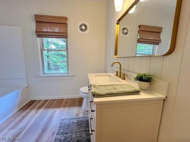 713 N Broadway St, New Philadelphia, OH 44663 - bathroom featuring wood finished floors, vanity, toilet, and baseboards