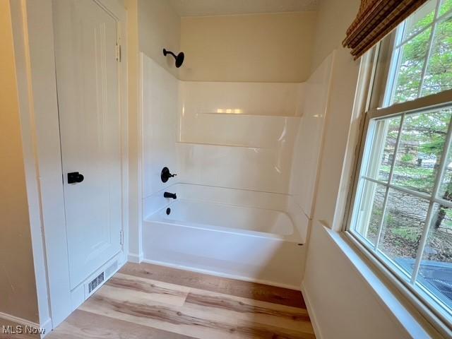 713 N Broadway St, New Philadelphia, OH 44663 - bathroom with wood finished floors, shower / washtub combination, and baseboards
