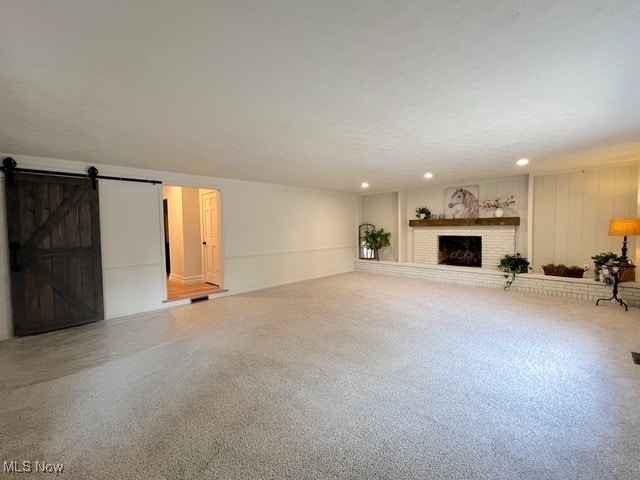 713 N Broadway St, New Philadelphia, OH 44663 - unfurnished living room with a barn door, a fireplace, and recessed lighting