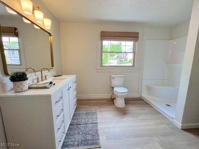 713 N Broadway St, New Philadelphia, OH 44663 - bathroom featuring baseboards, toilet, vanity, a shower, and wood finished floors
