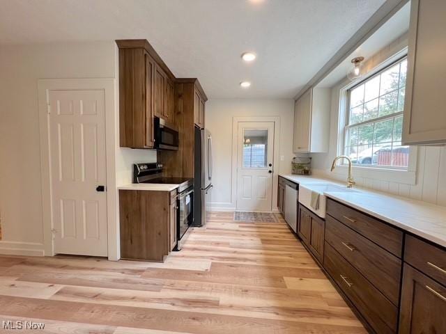 713 N Broadway St, New Philadelphia, OH 44663 - kitchen with appliances with stainless steel finishes, light wood-style flooring, light countertops, a sink, and recessed lighting