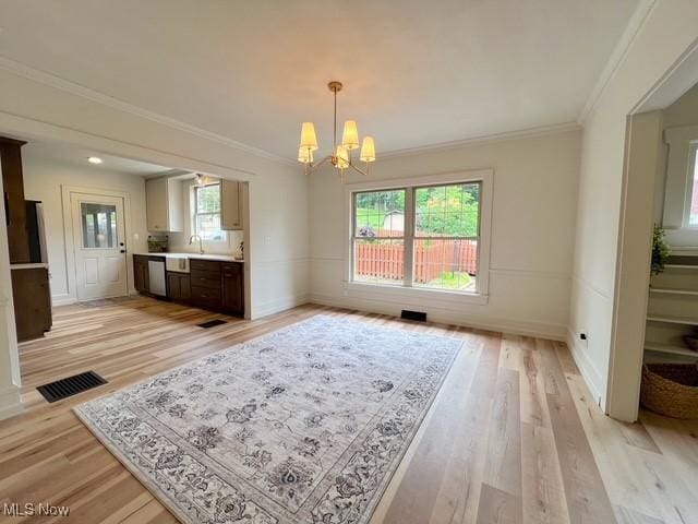 713 N Broadway St, New Philadelphia, OH 44663 - unfurnished dining area with a chandelier, ornamental molding, plenty of natural light, and light wood-style flooring
