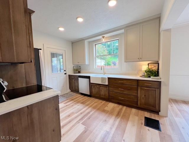 713 N Broadway St, New Philadelphia, OH 44663 - kitchen featuring dishwasher, a sink, light wood finished floors, light countertops, and recessed lighting