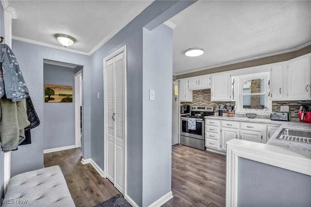 kitchen with stainless steel range with electric stovetop, ornamental molding, backsplash, light countertops, and dark wood-type flooring