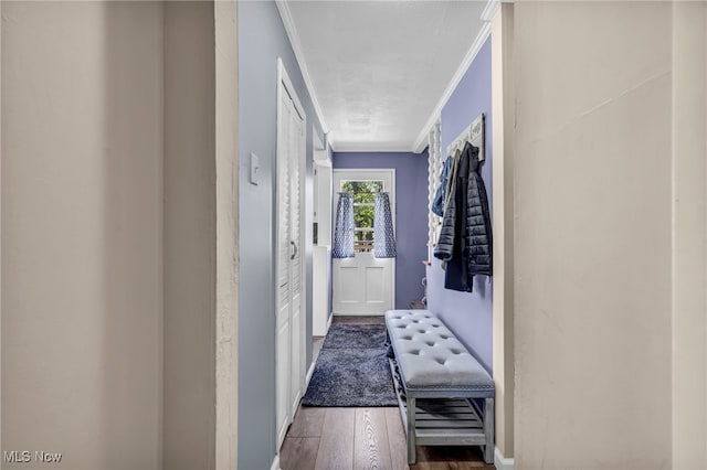 hallway with crown molding, wood finished floors, and baseboards