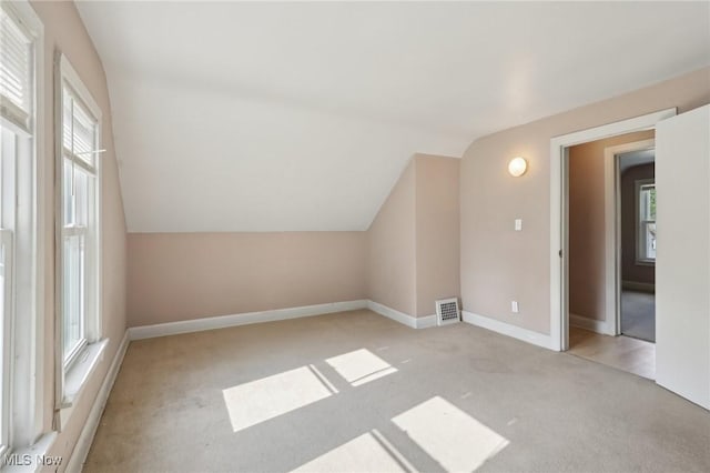 1540 Grand Park Ave, Akron, OH 44310 - additional living space with light colored carpet, vaulted ceiling, plenty of natural light, and baseboards