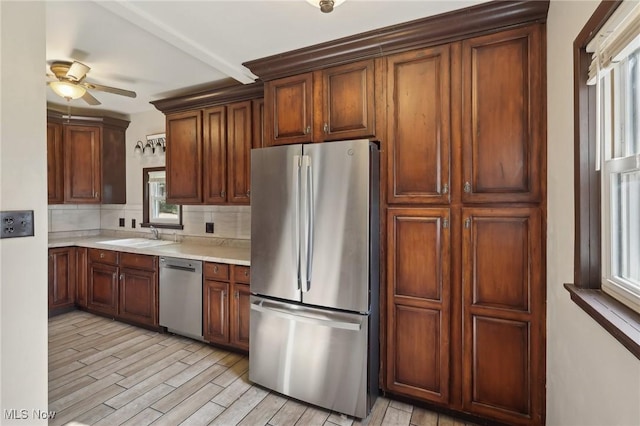 1540 Grand Park Ave, Akron, OH 44310 - kitchen featuring appliances with stainless steel finishes, backsplash, a ceiling fan, light countertops, and light wood-type flooring