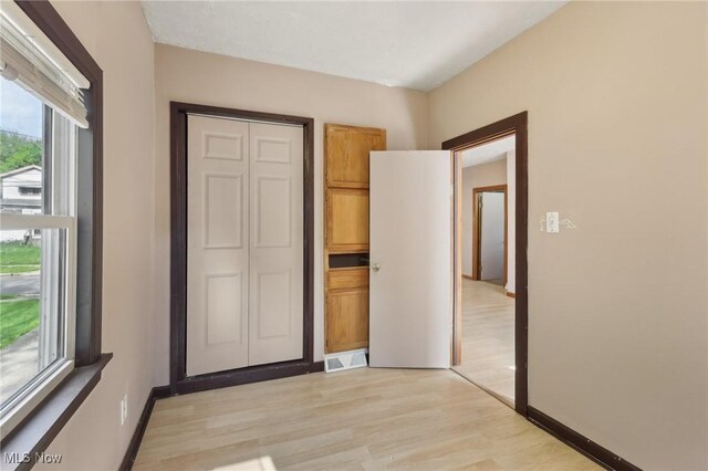 1540 Grand Park Ave, Akron, OH 44310 - unfurnished bedroom featuring light wood finished floors, a closet, and baseboards