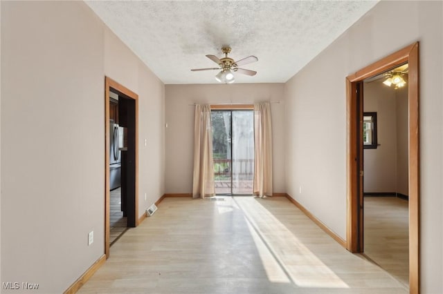 1540 Grand Park Ave, Akron, OH 44310 - empty room featuring ceiling fan, light wood finished floors, a textured ceiling, and baseboards