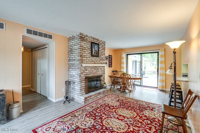 9942 Pebble Beach Cv, Reminderville, OH 44202 - living room featuring wood finished floors, a brick fireplace, and baseboards