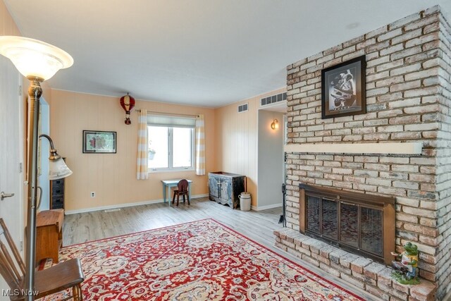 9942 Pebble Beach Cv, Reminderville, OH 44202 - living room featuring wood finished floors, a brick fireplace, and baseboards