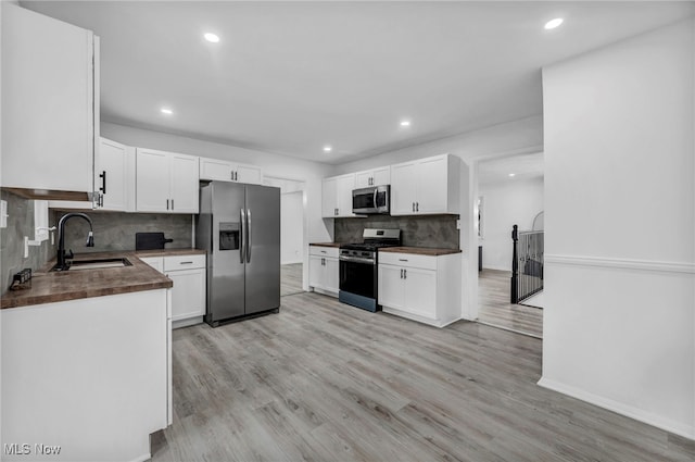 2162 Daniels Ave, Akron, OH 44312 - kitchen with stainless steel appliances, a sink, decorative backsplash, recessed lighting, and light wood-style floors