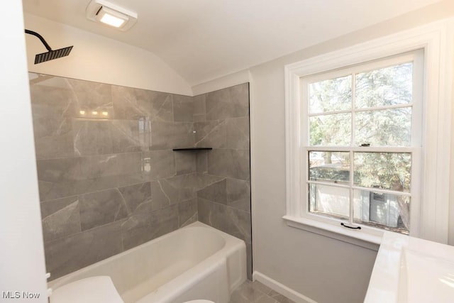 bathroom featuring baseboards, toilet, vaulted ceiling, and bathing tub / shower combination