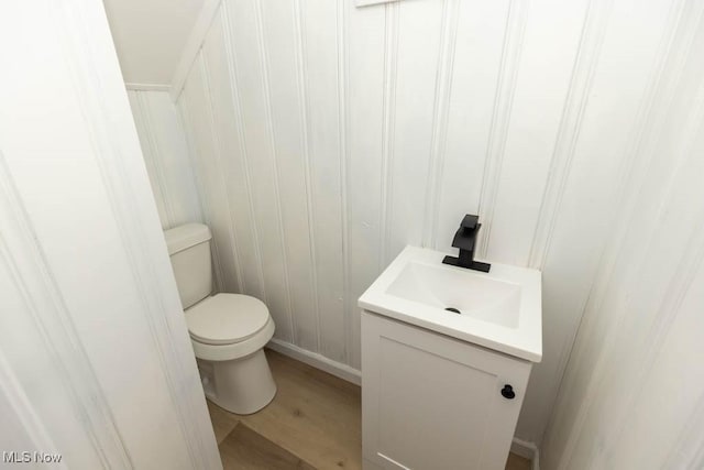 bathroom featuring toilet, wood finished floors, and vanity