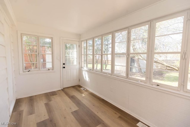 unfurnished sunroom featuring wood finished floors and baseboards
