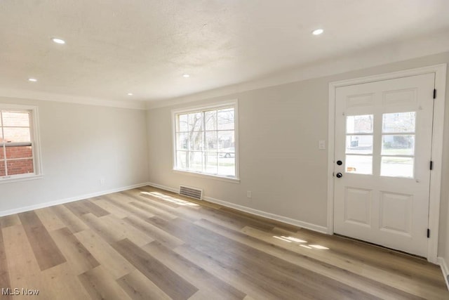 entryway with healthy amount of natural light, baseboards, recessed lighting, and light wood-style flooring