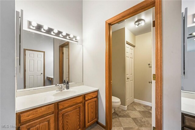 2889 Charing Cross Rd NW, Canton, OH 44708 - bathroom featuring vanity, toilet, and baseboards