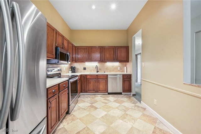 2889 Charing Cross Rd NW, Canton, OH 44708 - kitchen with appliances with stainless steel finishes, a sink, light countertops, decorative backsplash, and brown cabinets