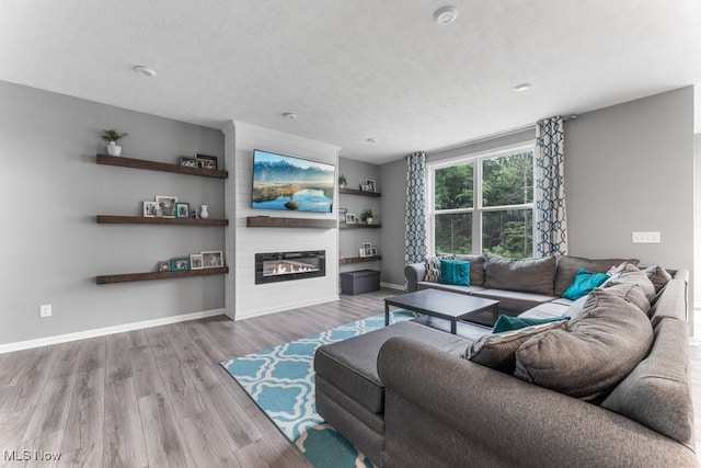 1726 Cobham Ln, Wadsworth, OH 44281 - living area with wood finished floors, a fireplace, baseboards, and a textured ceiling