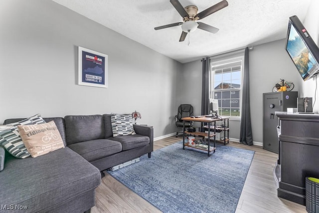 1726 Cobham Ln, Wadsworth, OH 44281 - living room with a ceiling fan, a desk, light wood-style floors, a textured ceiling, and baseboards