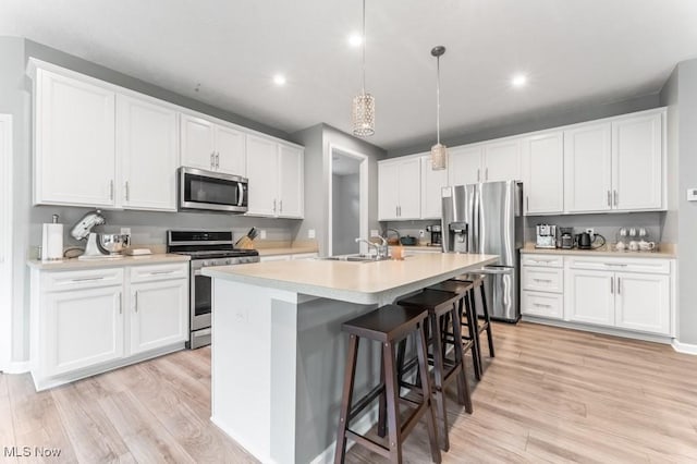 1726 Cobham Ln, Wadsworth, OH 44281 - kitchen featuring stainless steel appliances, a sink, a center island with sink, recessed lighting, and light wood-style floors