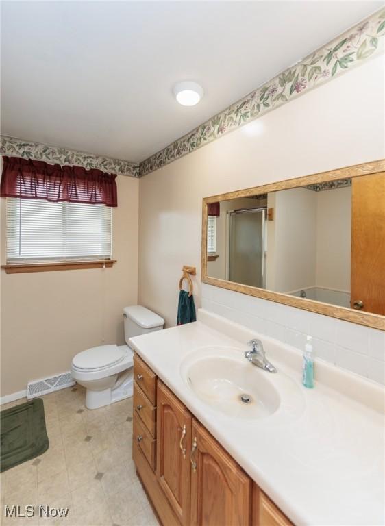 347 Beeler Dr, Berea, OH 44017 - full bath with vanity, toilet, baseboards, and a shower with shower door