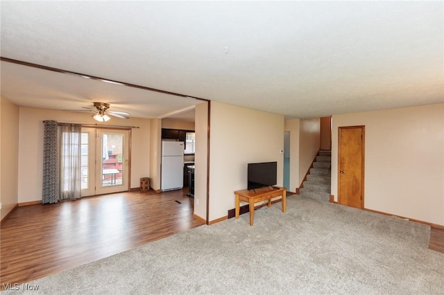 347 Beeler Dr, Berea, OH 44017 - unfurnished living room featuring stairs, carpet flooring, baseboards, wood finished floors, and ceiling fan