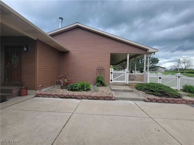 property entrance featuring a gate, a patio, and fence
