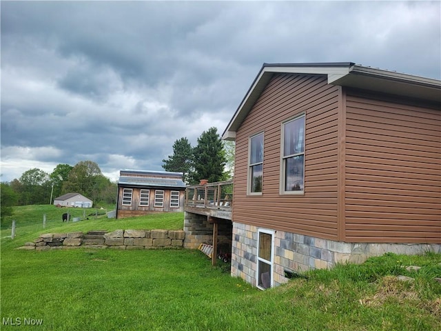 view of property exterior with a yard and a wooden deck