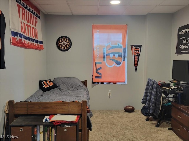 bedroom featuring carpet flooring and a drop ceiling