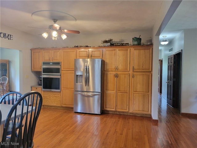 kitchen featuring appliances with stainless steel finishes, light wood-style floors, and ceiling fan