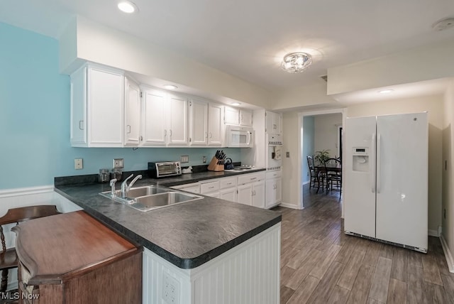 613-3 Fairington Oval, Aurora, OH 44202 - kitchen featuring white appliances, dark countertops, a sink, white cabinetry, and a peninsula